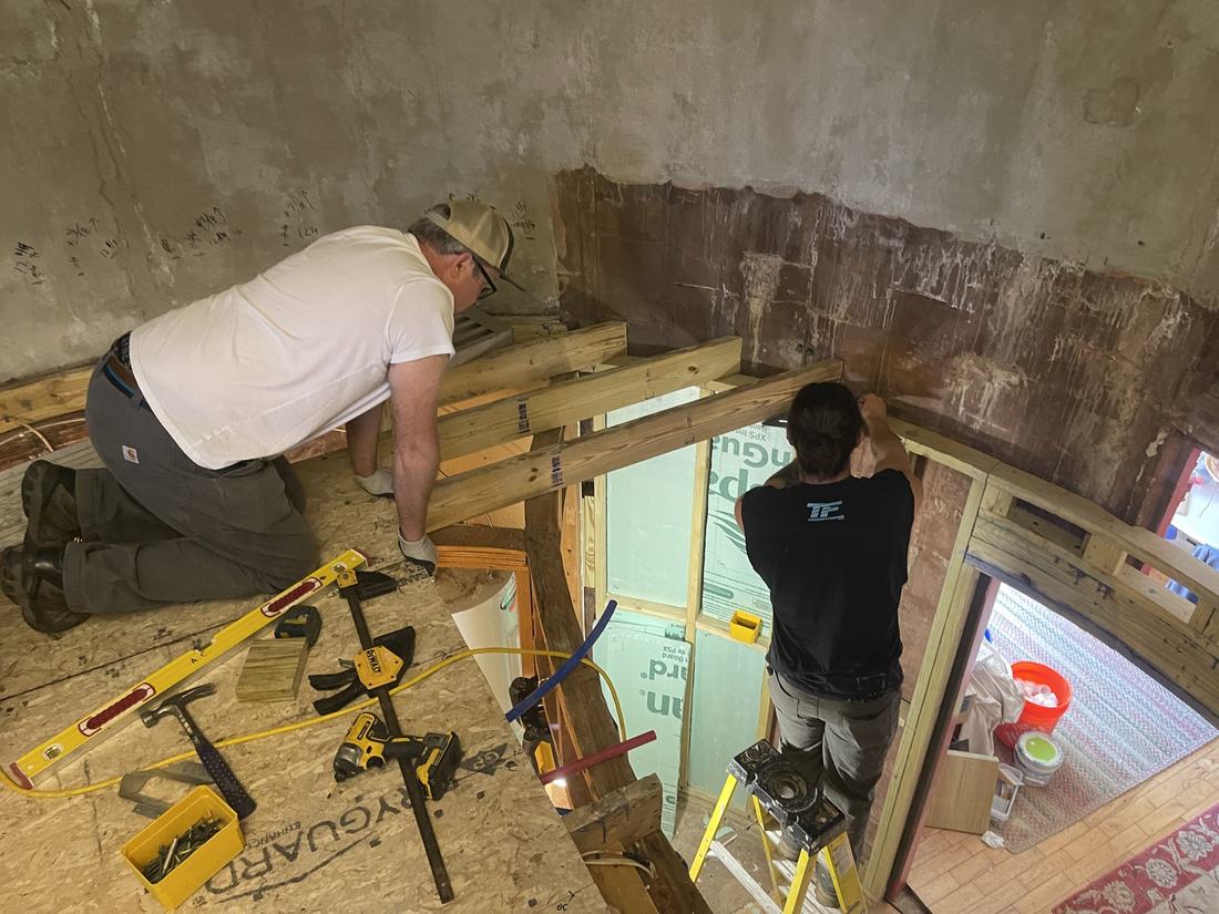 Two of the crew framing a new window opening on site