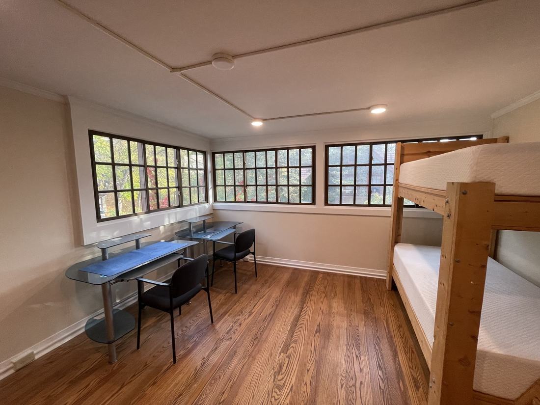 A finished bunk room with steel-framed windows, built-in bunks and a refinished wood floor