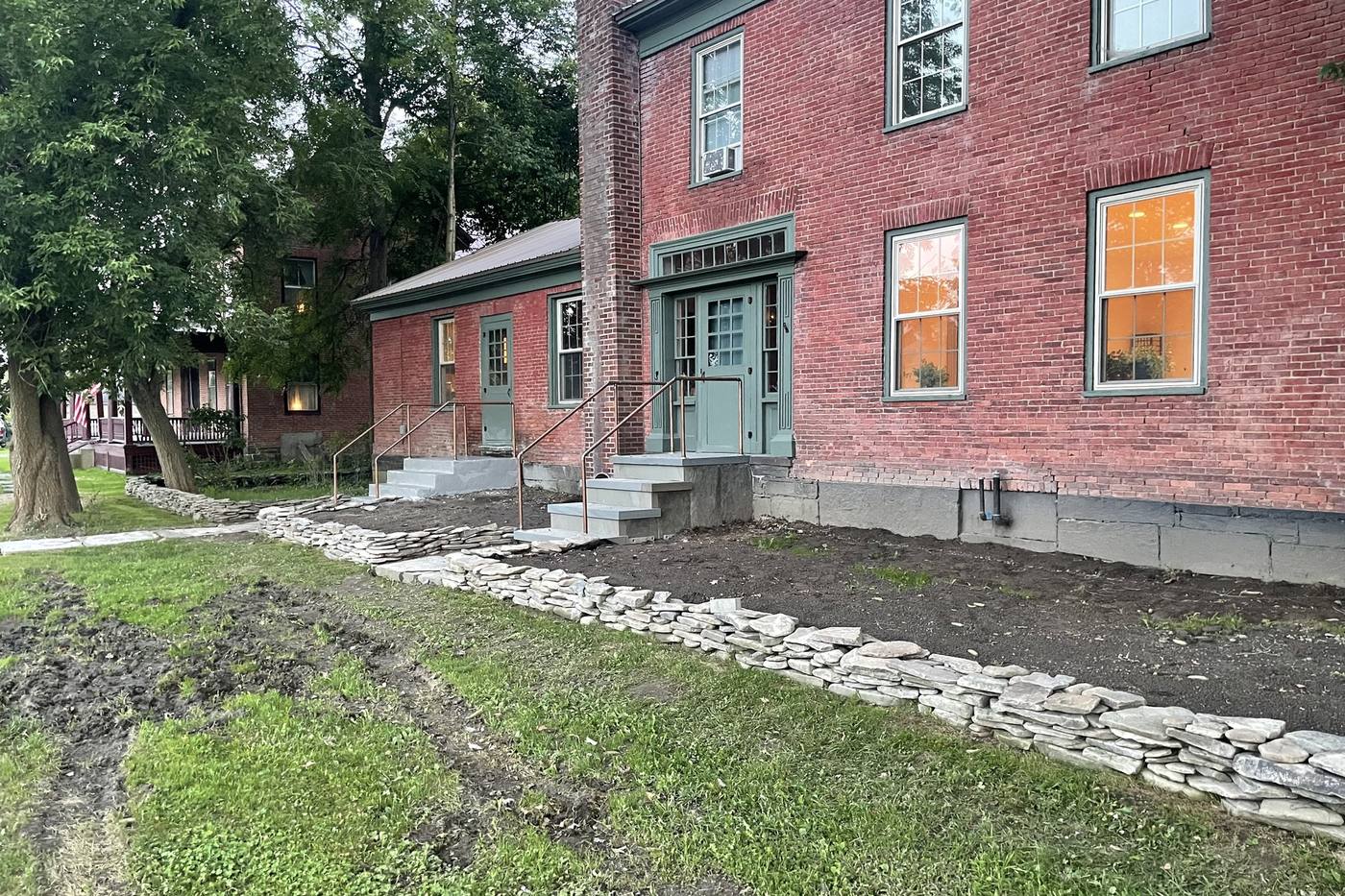 A brick house with new bluestone steps and a dry stone retaining wall