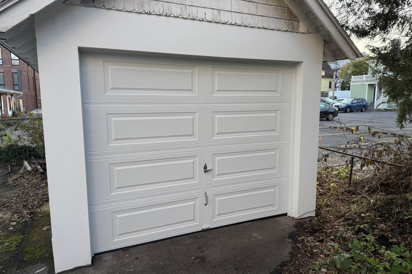 A rebuilt garage with new siding and an overhead door